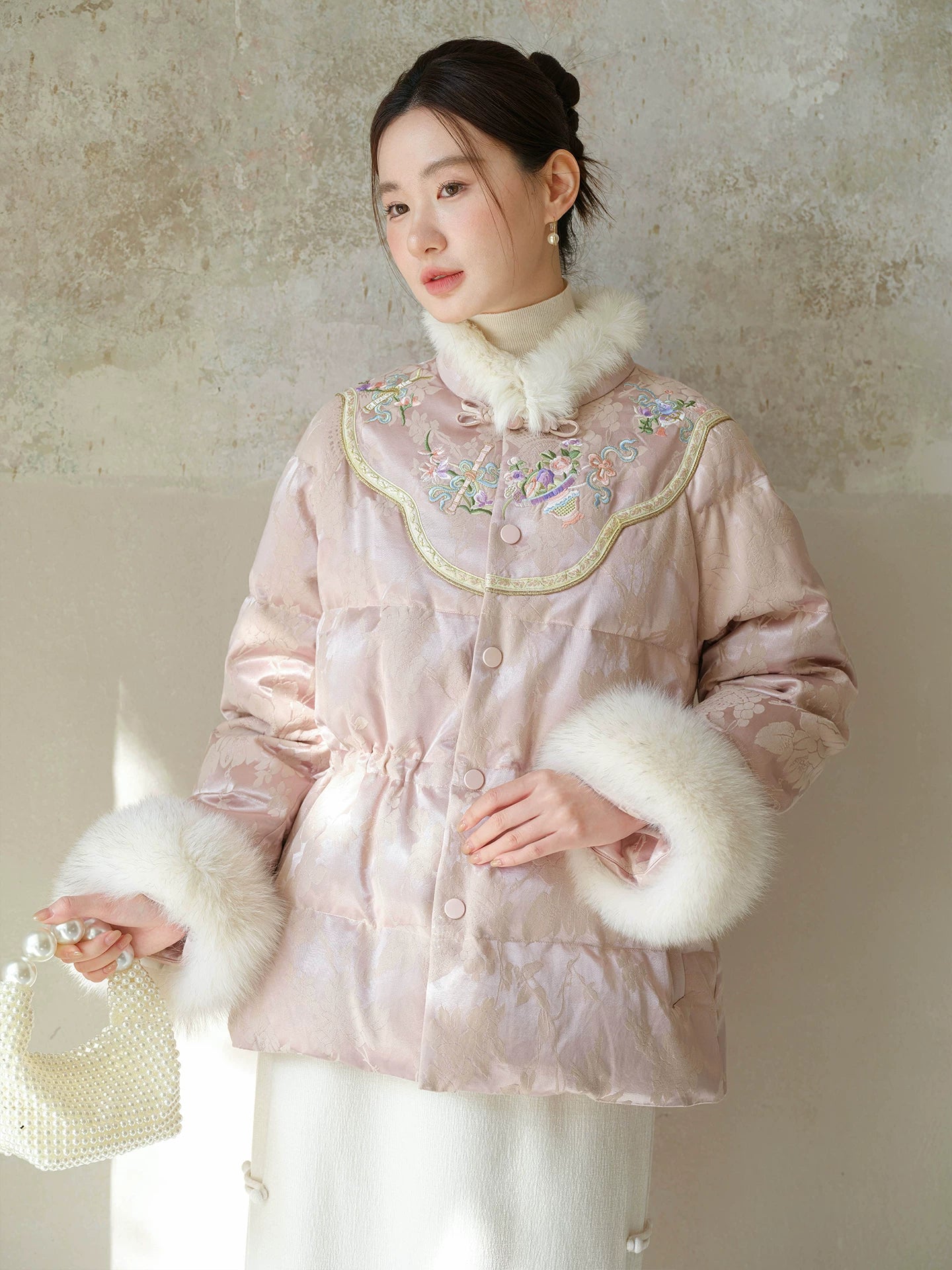 Front styling view of the Pink-Lilac jacquard down jacket with fur trim, with jacquard shell, plush fur trim and warm cropped silhouette.