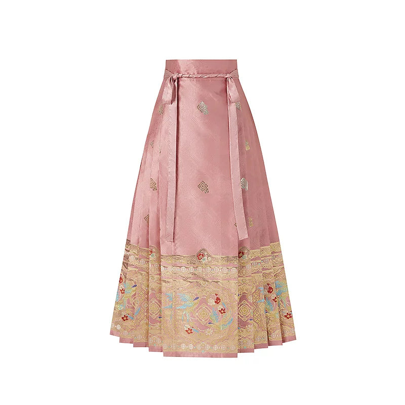 Pink magpie mamian skirt with small woven motifs, waist ties and an ornate gold-tone hem border