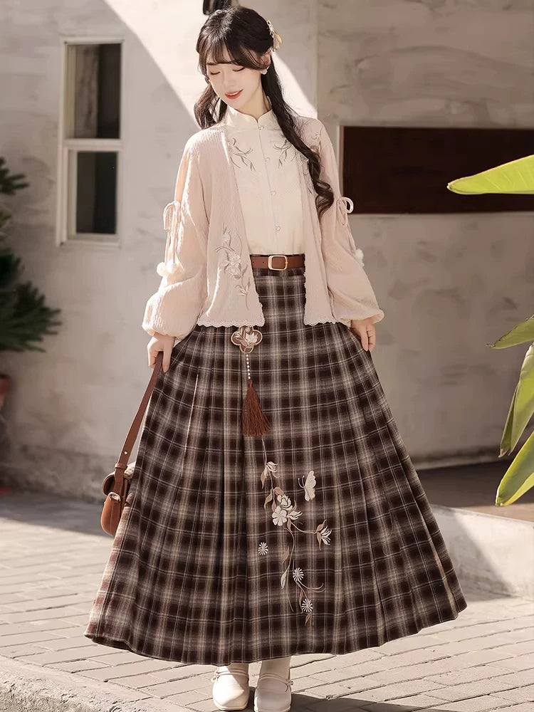 Brown plaid skirt with floral embroidery styled with an ivory blouse and pink cardigan