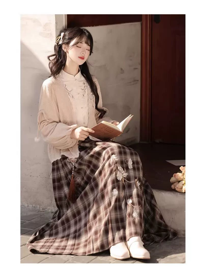 Seated view of the plaid skirt and pink cardigan showing the skirt drape