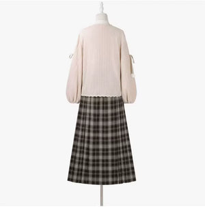 Back view of the pink cardigan and brown plaid skirt on a dress form