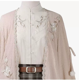 Close-up of the ivory standing collar, floral embroidery and textured pink cardigan