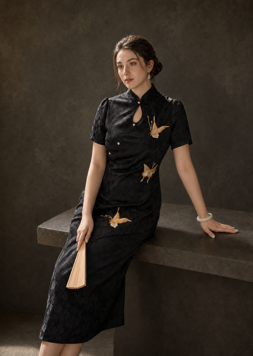 Black butterfly jacquard cheongsam seated view showing fit, sheen and embroidery