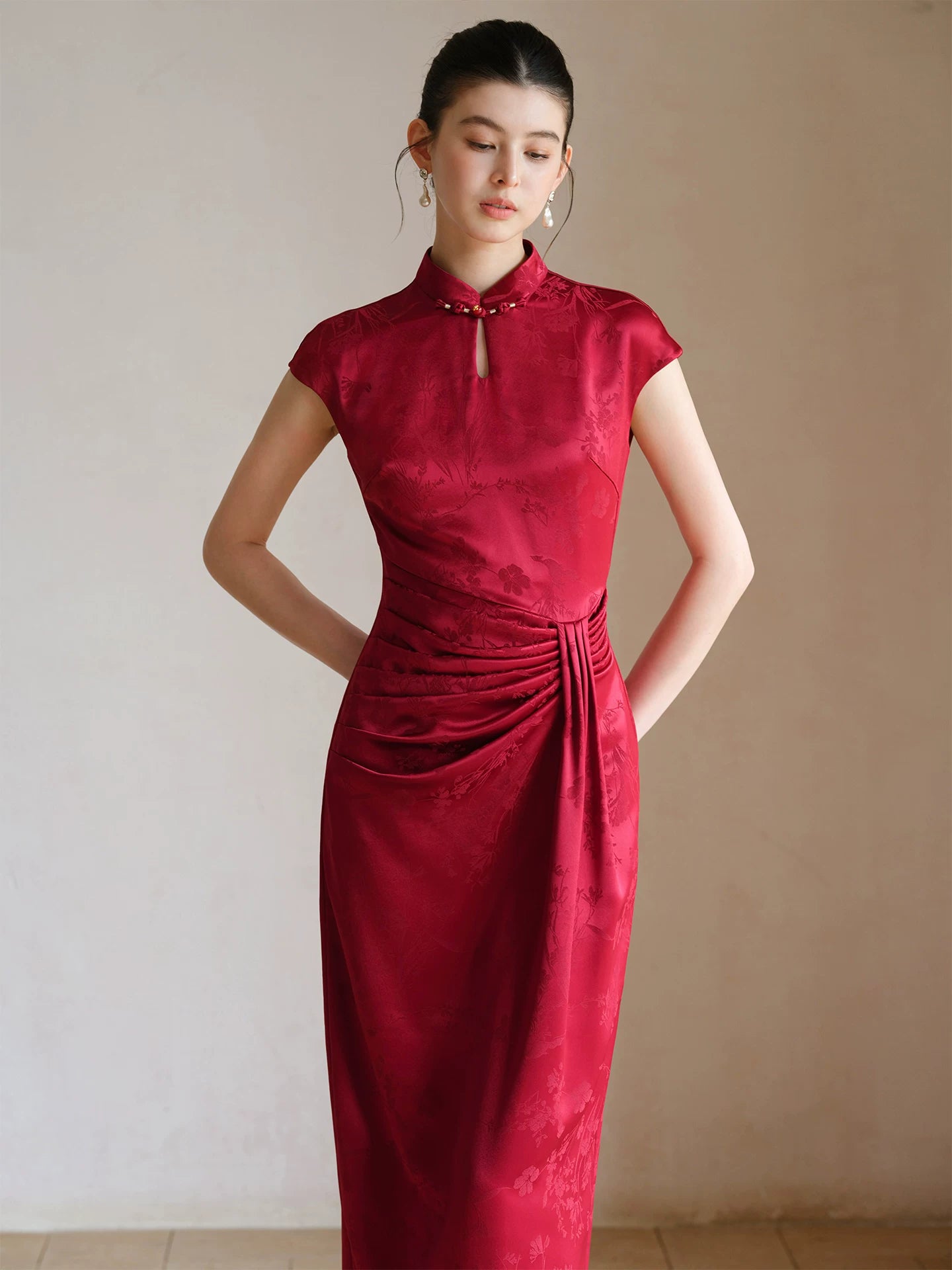 Design view of the Ruby Red acetate jacquard pleated qipao dress, highlighting acetate jacquard, sculpted pleats and elegant Chinese dress silhouette.