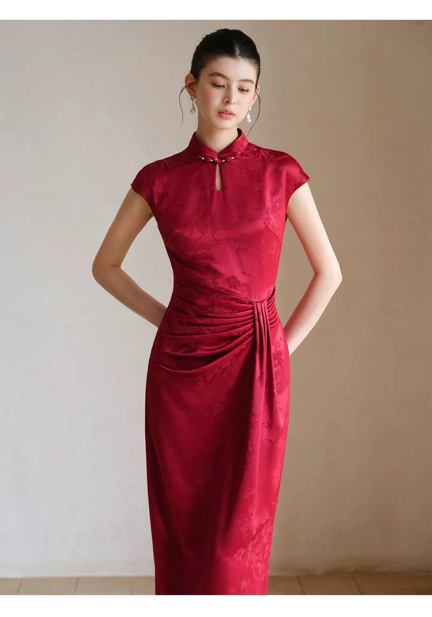 Additional styling view of the Ruby Red acetate jacquard pleated qipao dress, showing the garment's shape, texture and finish.