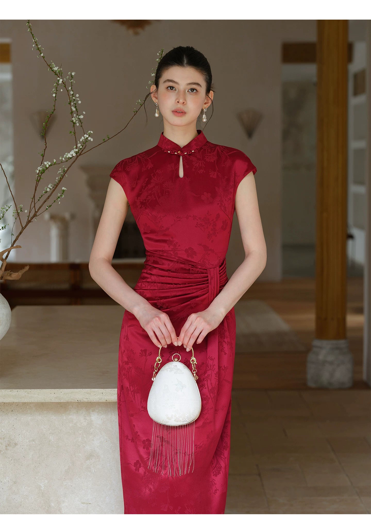 Front styling view of the Ruby Red acetate jacquard pleated qipao dress, with acetate jacquard, sculpted pleats and elegant Chinese dress silhouette.