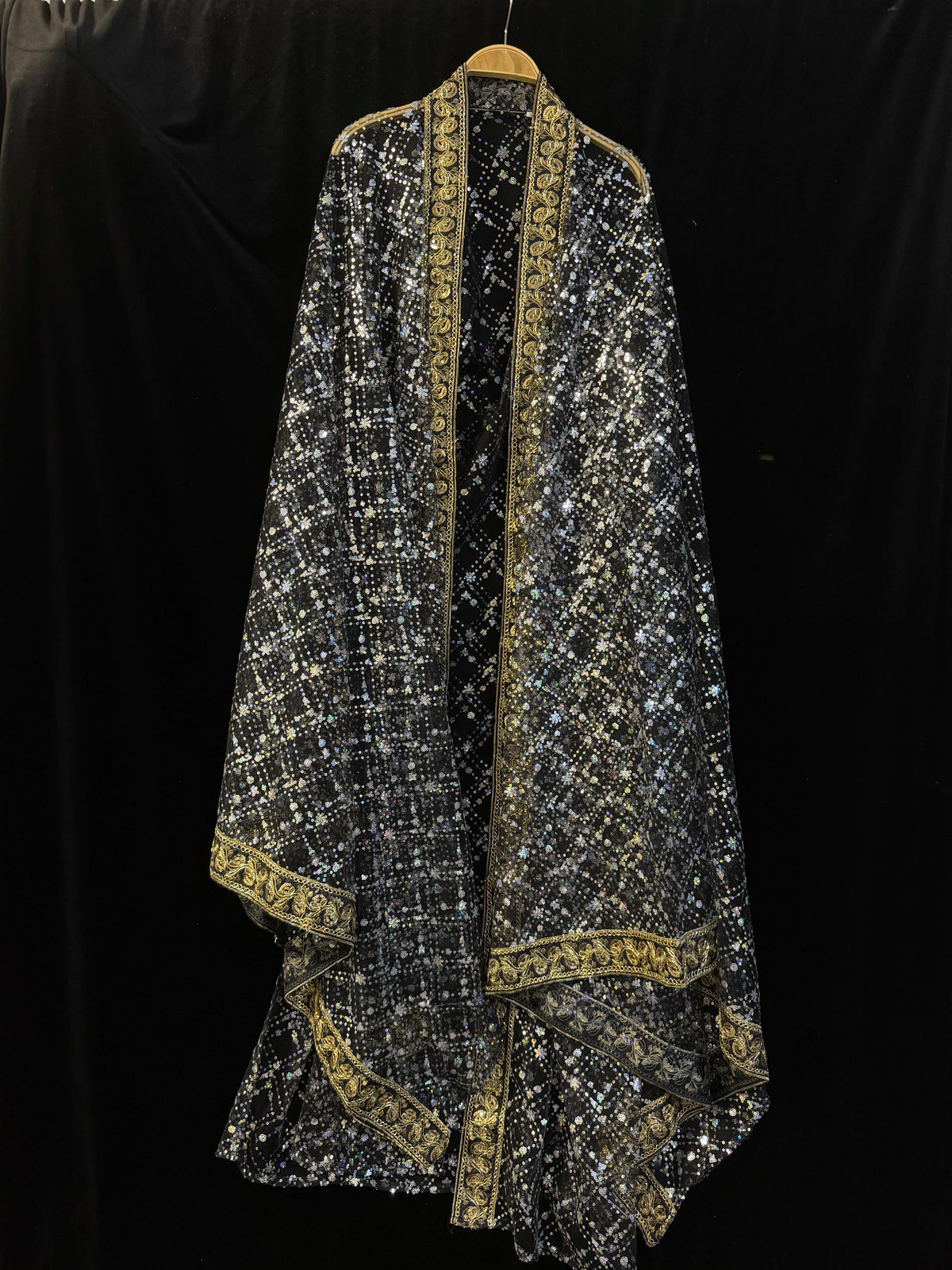 Black sheer sequin Hanfu robe with ornate gold-tone borders against a black backdrop