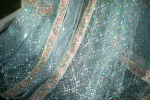 Close detail of shimmering blue sequin mesh beside the robe front border
