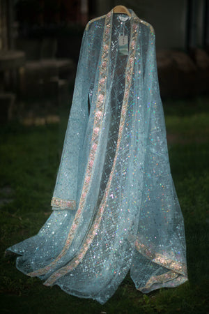 Blue sequin Hanfu robe displayed alone on a hanger against an outdoor background