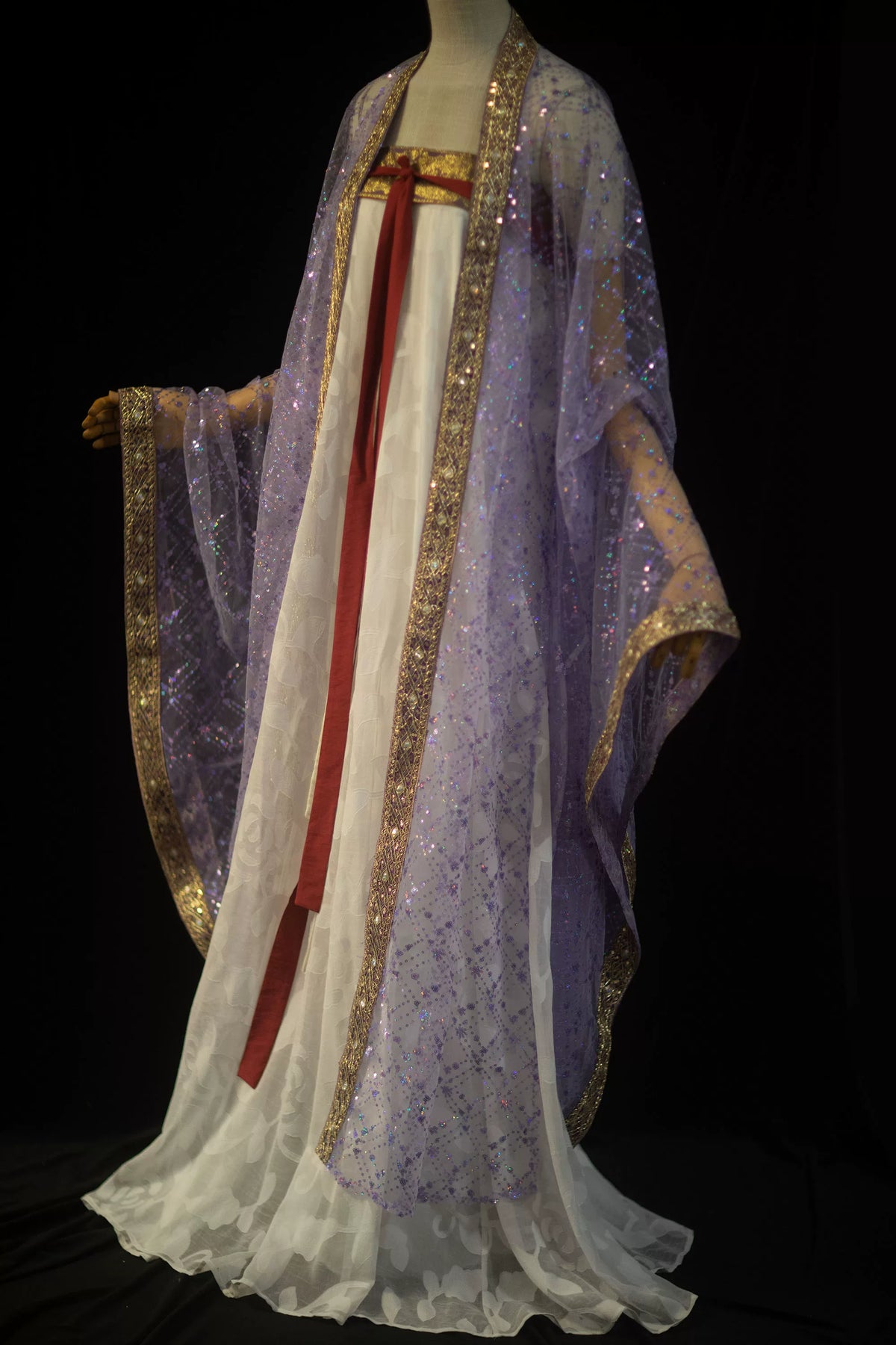 Full-length purple sequin robe styled over a flowing white skirt on a mannequin