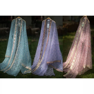 Three sheer sequin Hanfu robes in blue, purple and pink displayed on hangers outdoors