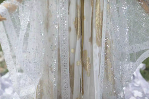 Close-up of white sequin robe panels and decorative white edging
