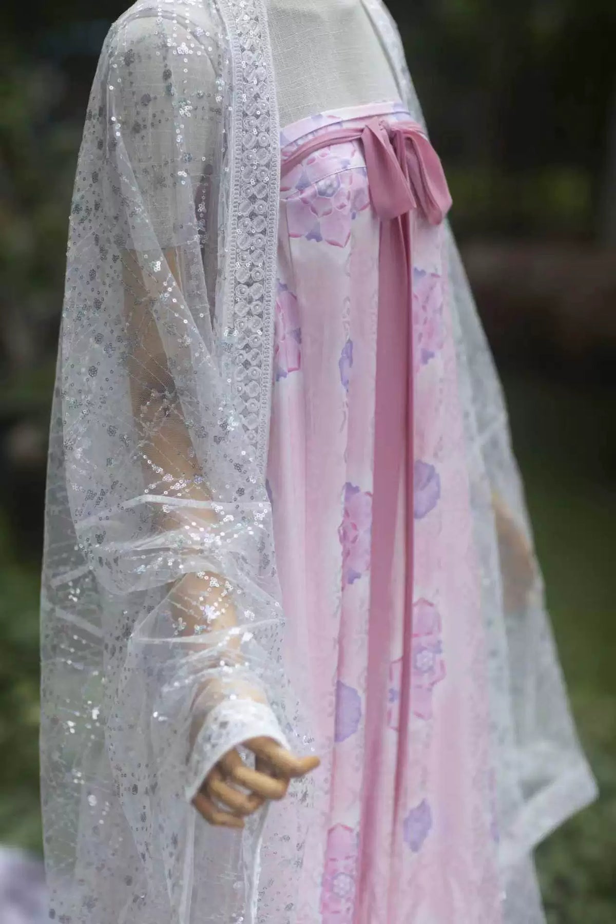 White pearl-sheen sequin Hanfu robe detail showing the wide sleeve and decorative edging
