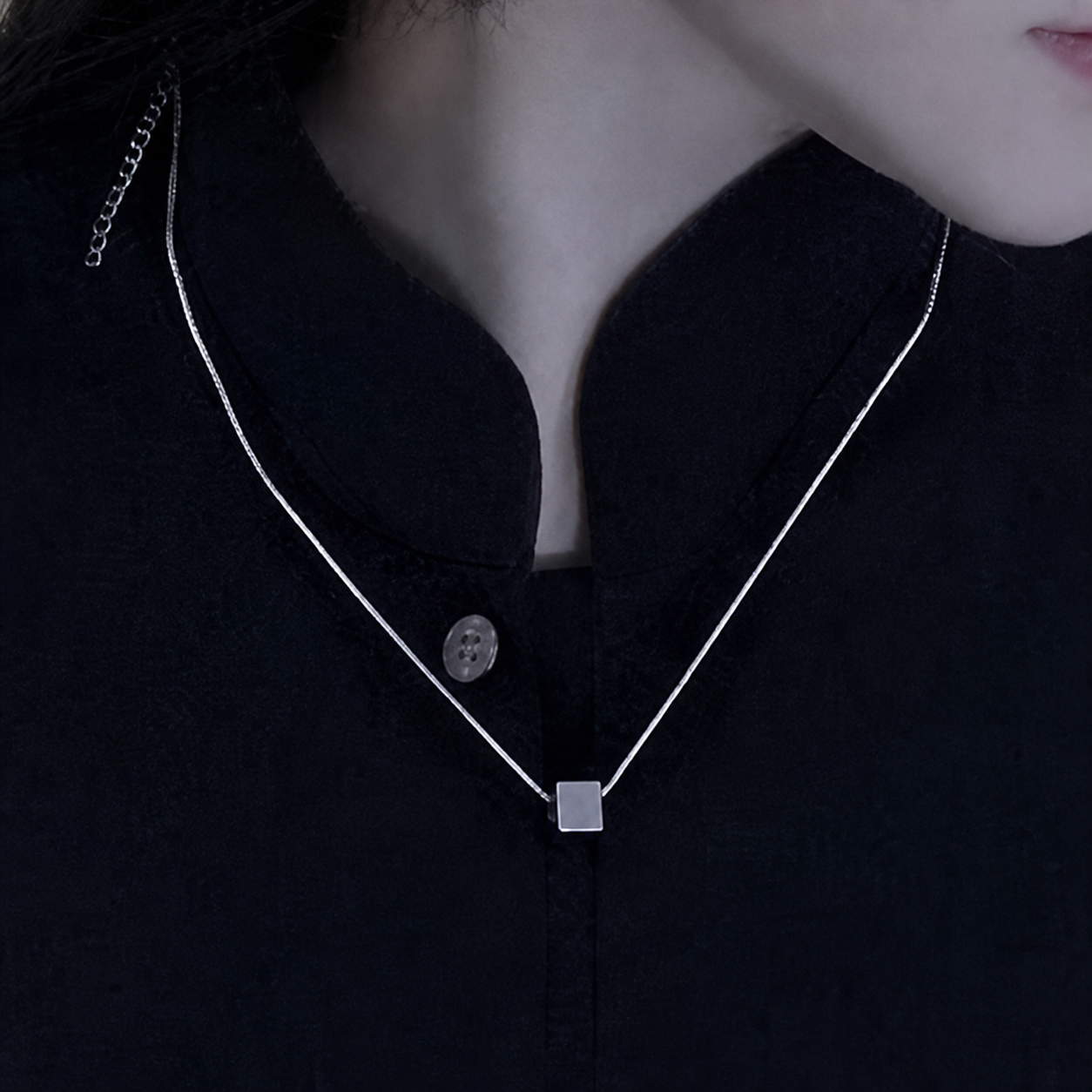 Silver shirt chain necklace on black calligraphy-style shirt