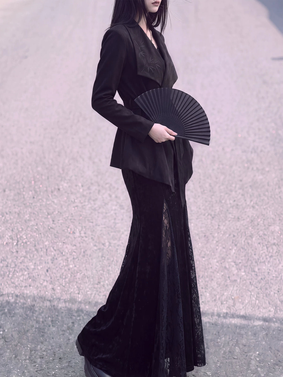 Side view of the black wrap jacket and asymmetric hem