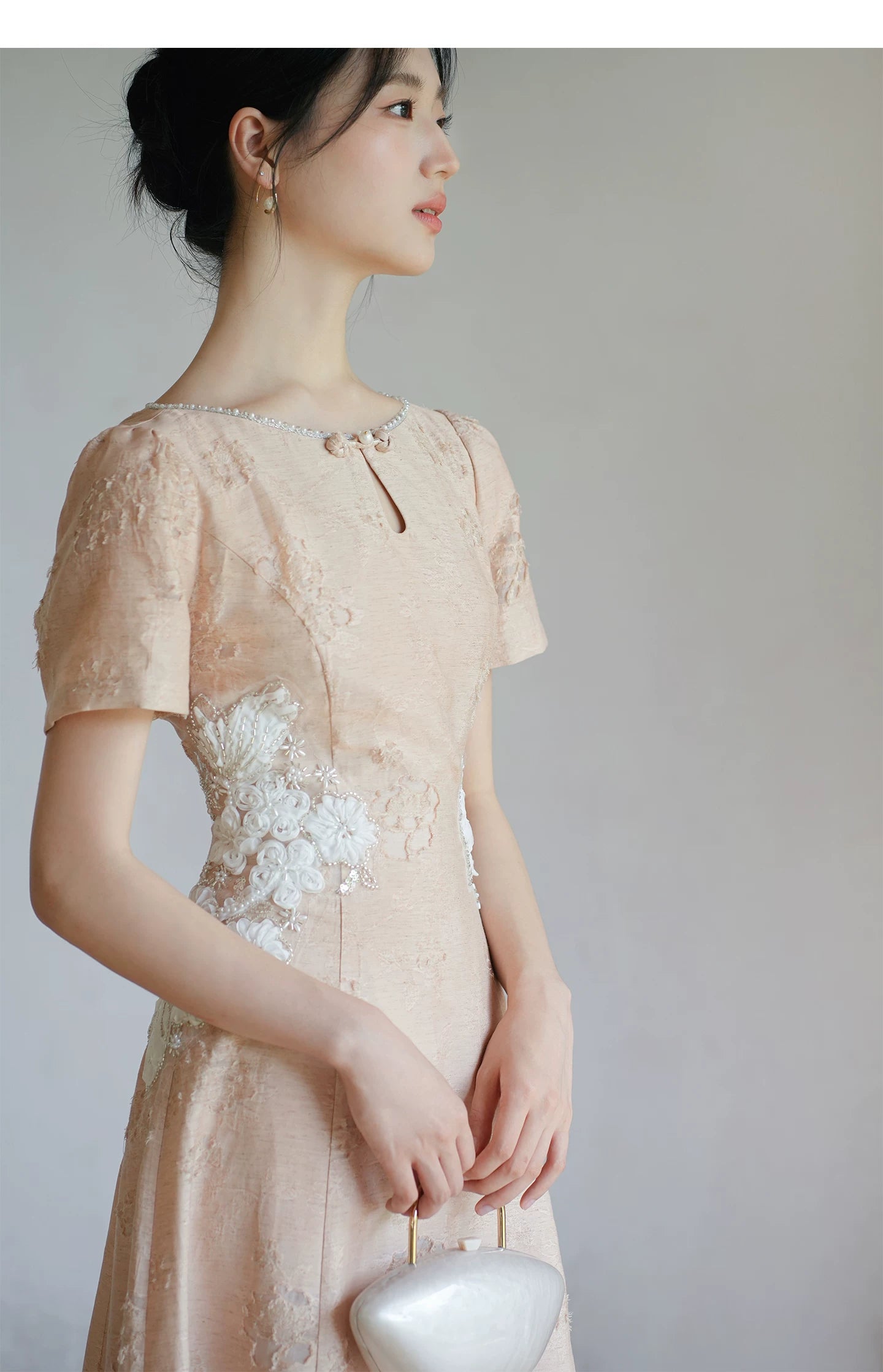 Additional styling view of the Soft Sand Pink floral applique cheongsam dress, showing the garment's shape, texture and finish.