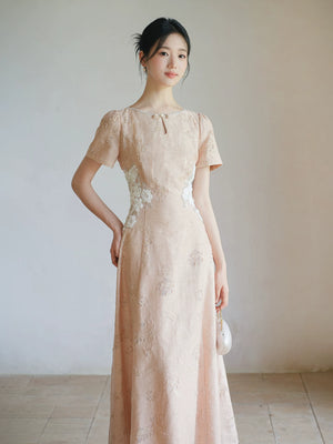 Soft Sand Pink floral applique cheongsam dress shown as a polished modern pink qipao dress, highlighting pearl neckline, floral waist applique and long A-line silhouette.