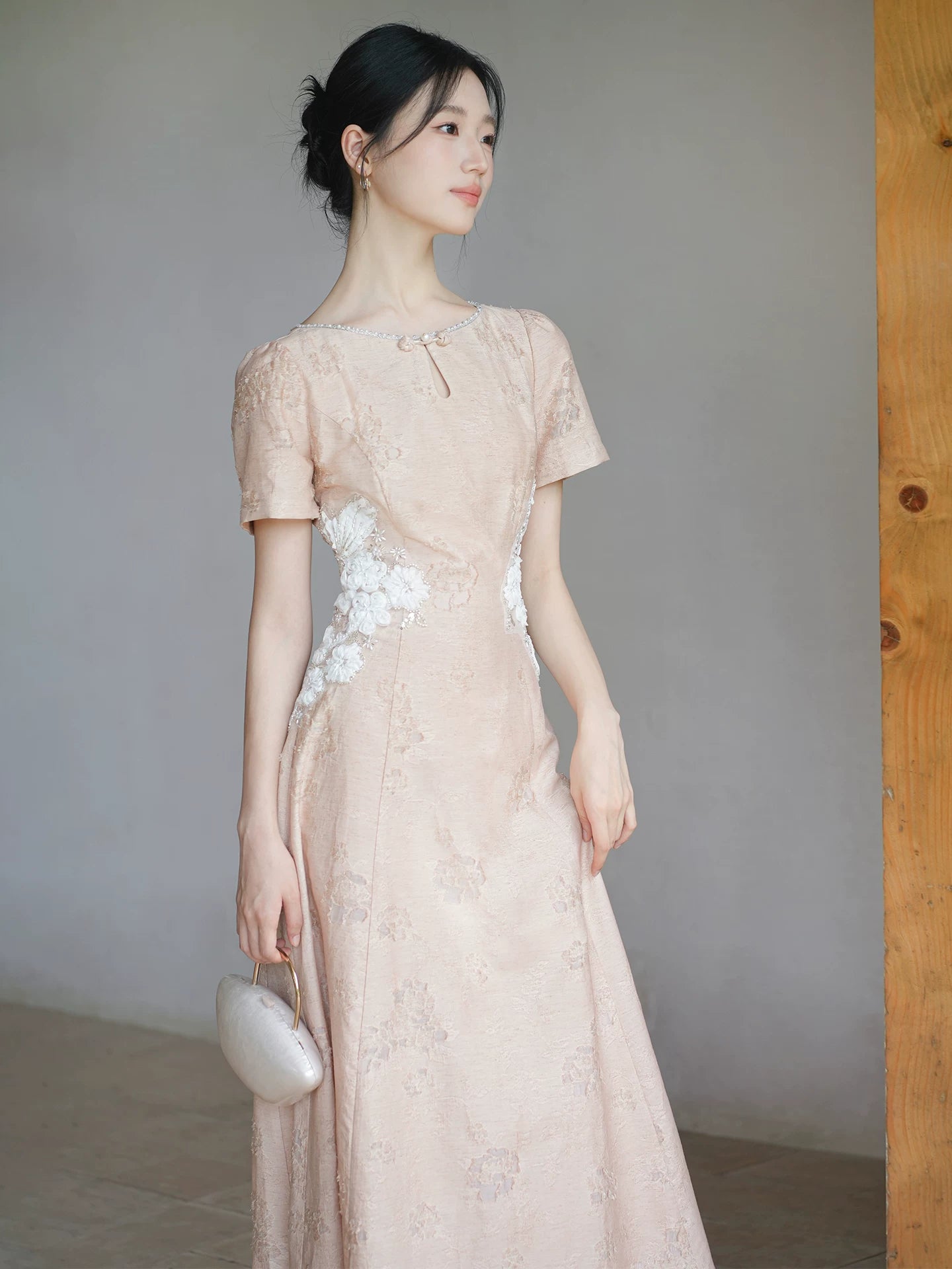 Three-quarter product view of the Soft Sand Pink floral applique cheongsam dress, a refined modern pink qipao dress for elegant occasions.