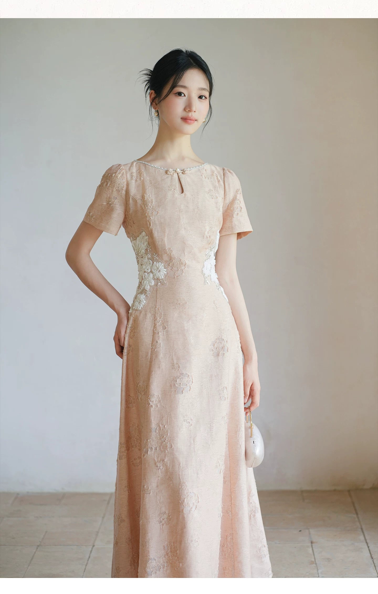 Soft Sand Pink floral applique cheongsam dress styled to show its fit and drape, including pearl neckline, floral waist applique and long A-line silhouette.
