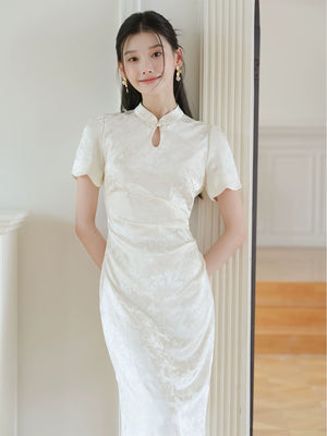Design view of the Soft White jacquard pleated qipao dress, highlighting subtle jacquard, fitted waist, front pleats and keyhole mandarin collar.