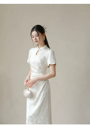 Additional styling view of the Soft White jacquard pleated qipao dress, showing the garment's shape, texture and finish.