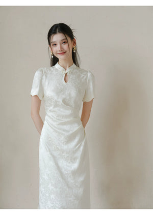 Detailed product image of the Soft White jacquard pleated qipao dress, showing fabric texture, finish and craftsmanship.