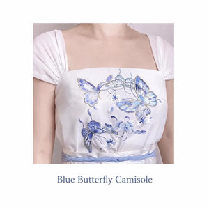 White camisole worn on a model to show the blue butterfly embroidery and broad shoulder straps