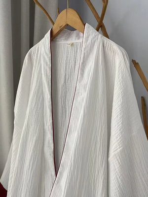 White cotton gauze robe showing wide sleeves and deep red cuff trim