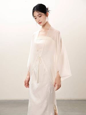 Design view of the White embroidered slip dress and sheer outer layer, highlighting embroidered slip dress, translucent outer layer and soft layered drape.