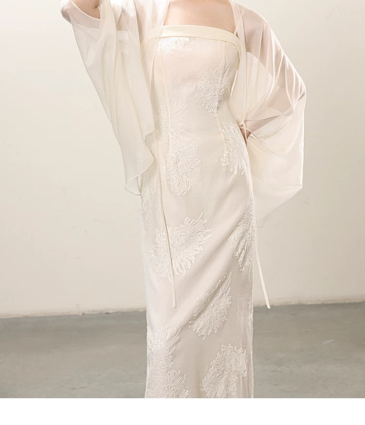 Detailed product image of the White embroidered slip dress and sheer outer layer, showing fabric texture, finish and craftsmanship.