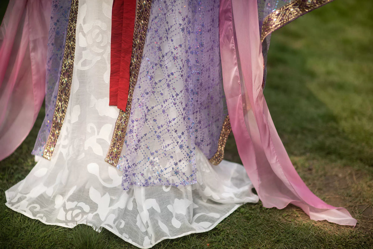 White Hanfu skirt hem beneath a purple sequin daxiushan robe, with a pink gold-print pibo shawl