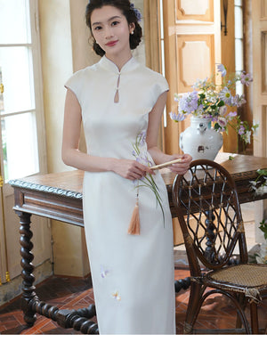 White iris satin qipao showing the floral embroidery at the waist