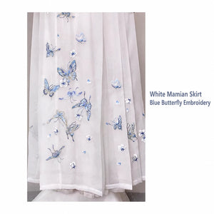 White mamian skirt close-up showing blue butterfly embroidery and the layered appearance of the sheer fabric