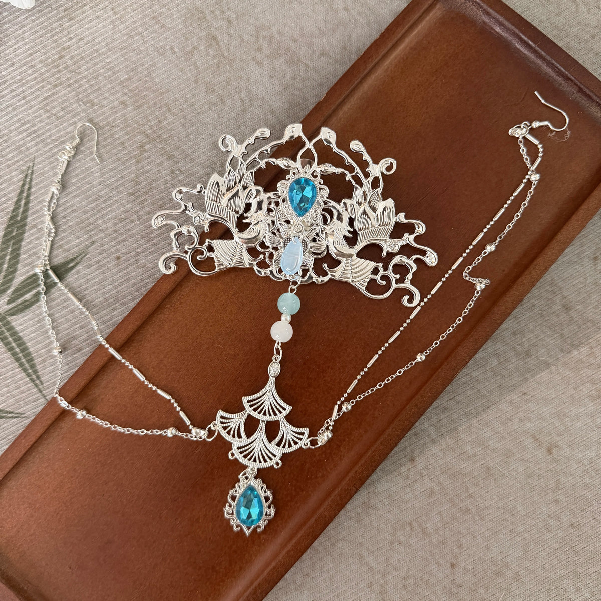 Silver-tone crown with blue accents laid flat