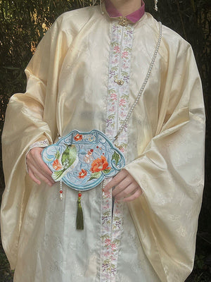 A beautiful blue Hanfu bag featuring intricate embroidery in a traditional Chinese pattern. The bag is made of high-quality materials and has a spacious interior, making it the perfect accessory for everyday use or special events. The blue color adds a pop of color to any outfit and showcases the fusion of traditional Chinese culture with modern fashion.